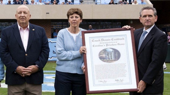 Dennis Craddock, left, was presented the Priceless Gem in October 2012 by Senior Associate Athletic Director Beth Mill and Athletic Director Bubba Cunningham. (Photo courtesy of UNC Athletics)